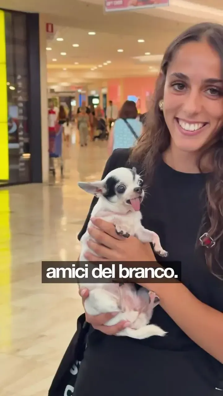 Una ragazza sorride con un chihuahua in braccio, al centro commerciale Le Vele